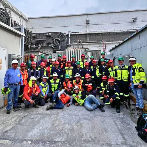Cuadrilla completa de iT Power Systems con casco y equipo de protección frente a una subestación industrial