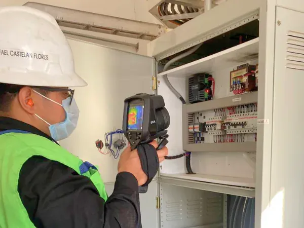 Ingeniero de iT Power Systems inspeccionando con cámara termográfica FLIR el interior de un tablero de control durante el levantamiento de datos en planta